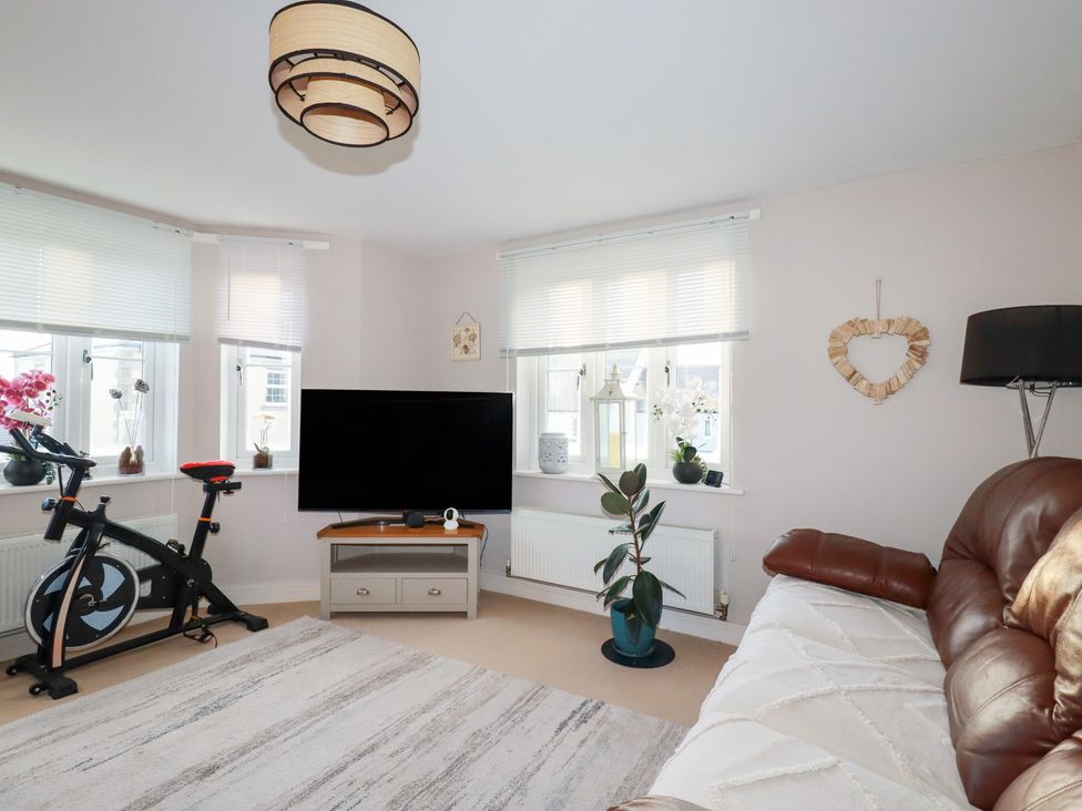 A living room with an exercise bike and television at 18 Pagoda Drive St. Austell