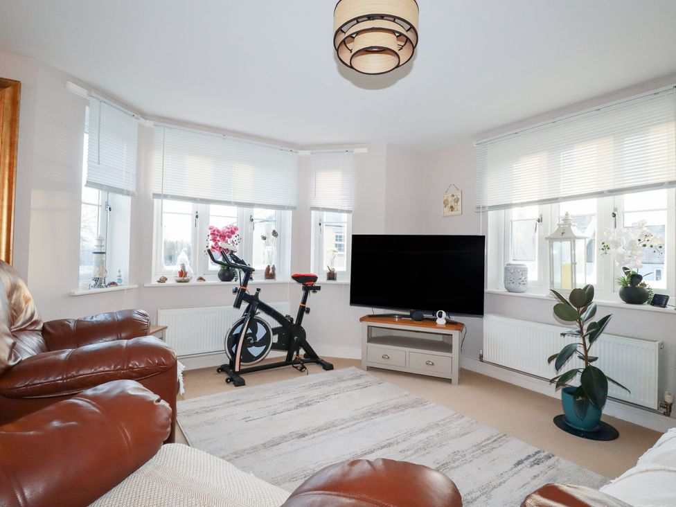 A living room with an exercise bike and a television at 18 Pagoda Drive St. Austell