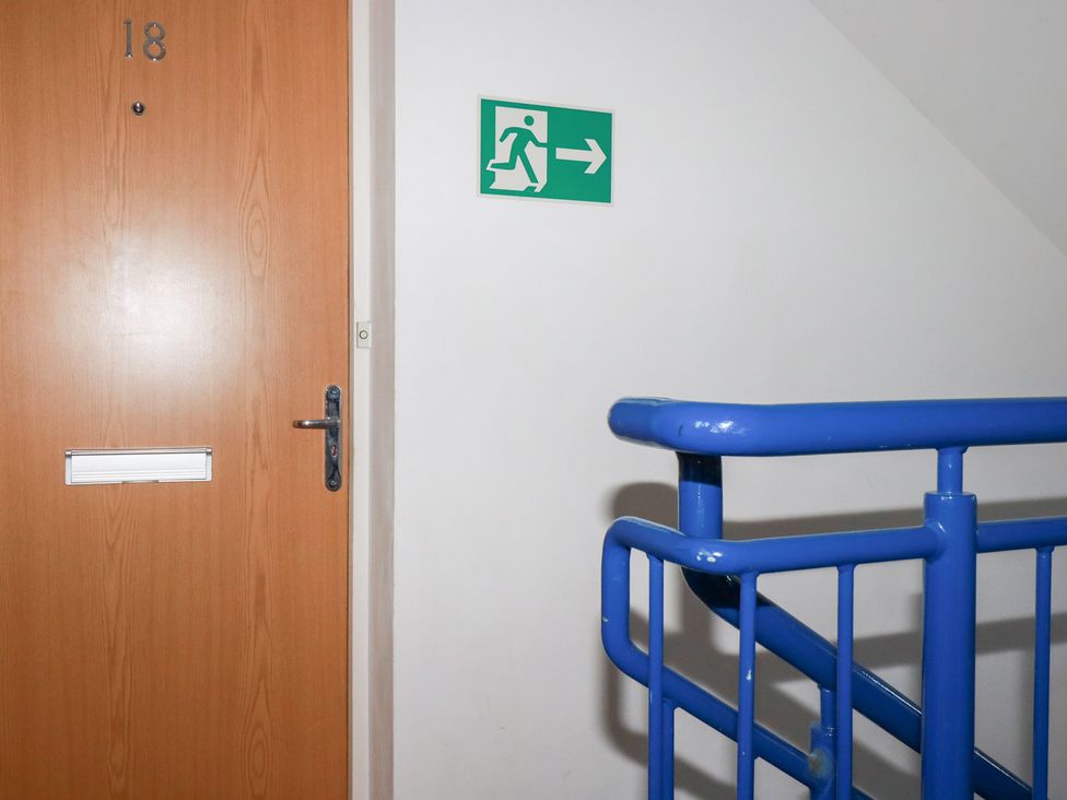 A door with number 18 and an exit sign near a staircase at 18 Pagoda Drive St. Austell