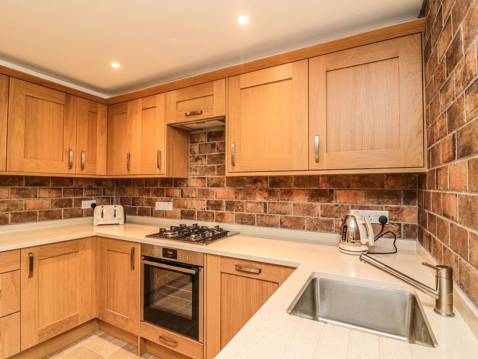 A kitchen with cabinets and appliances at The Coach House in Carnforth
