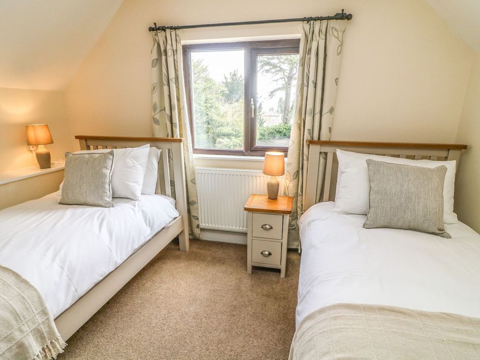A bedroom with two beds and a window at The Coach House in Carnforth