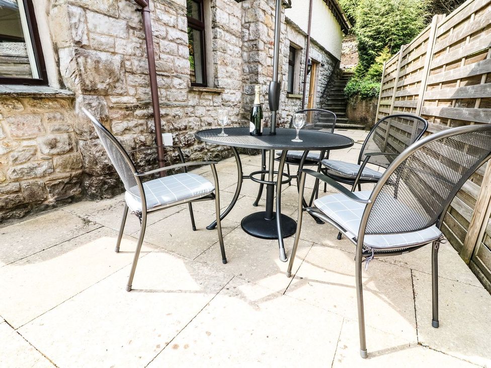 A table with chairs and a bottle on a patio at The Coach House Carnforth