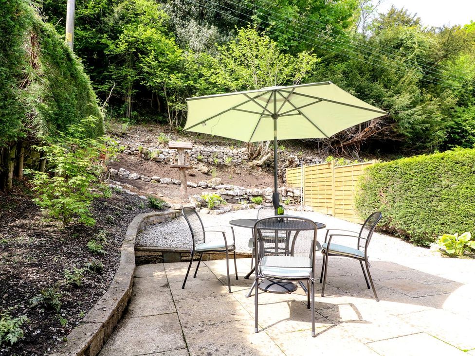 A garden with a table and chairs under an umbrella at The Coach House in Carnforth