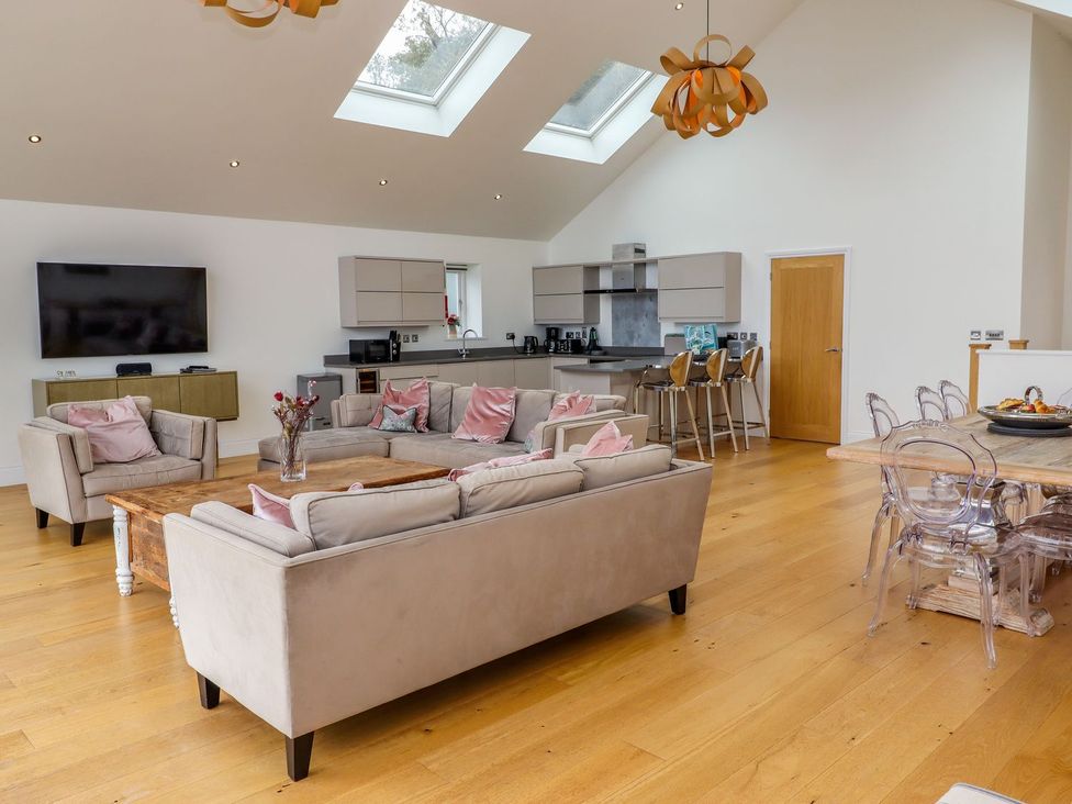 A living room with a kitchen area and a television at 2 Remera St. Ives