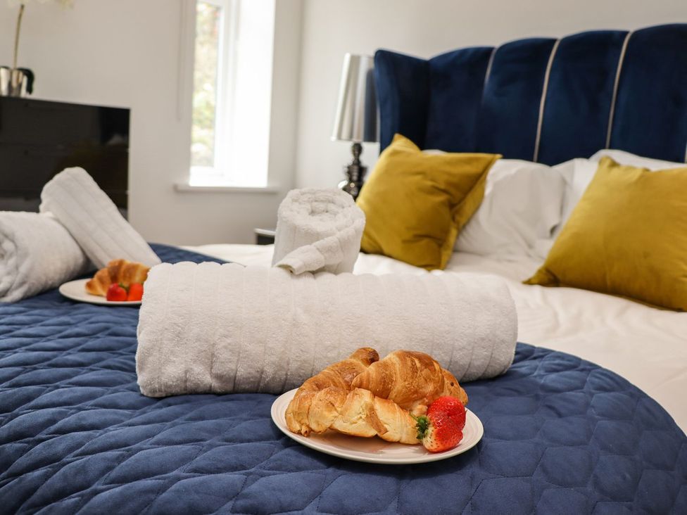A bedroom with towels and croissants on plates at 2 Remera in St. Ives