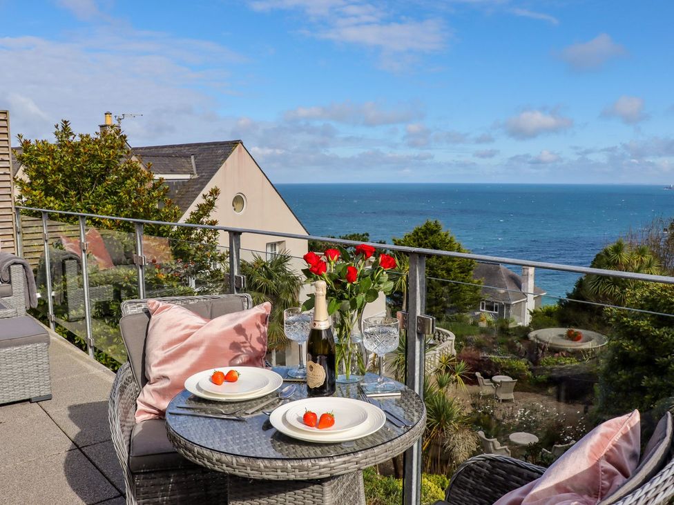 A balcony with dining setup and ocean view at 2 Remera in St. Ives