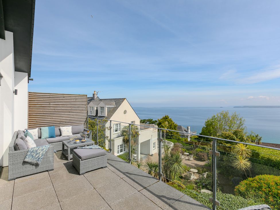 An outdoor area with a sofa and coffee table overlooking the sea at 2 Remera St Ives