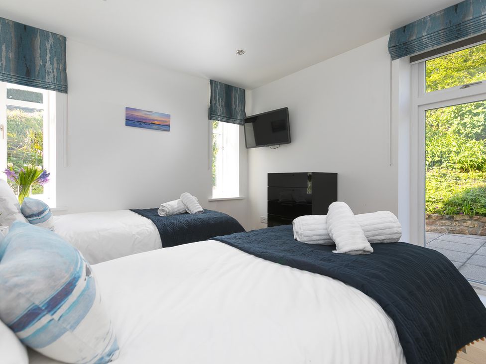 A bedroom with two beds and a television at 2 Remera in St Ives