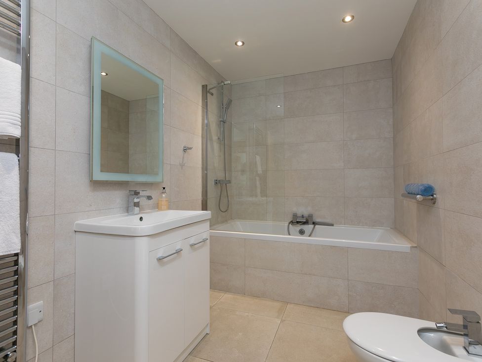 A bathroom with a bathtub, shower, sink, and toilet at 2 Remera in St Ives