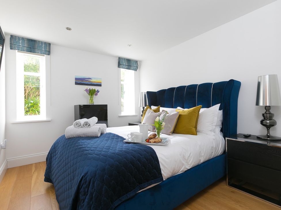 A bedroom with a bed and side table at 2 Remera in St Ives