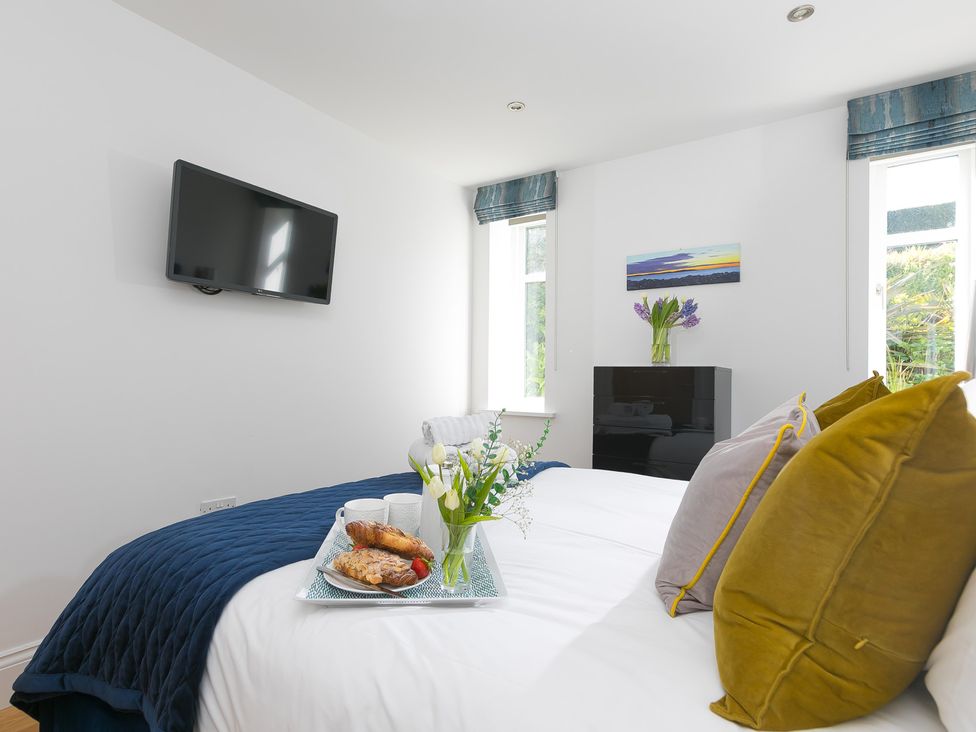 A bedroom with a bed and television at 2 Remera in St Ives
