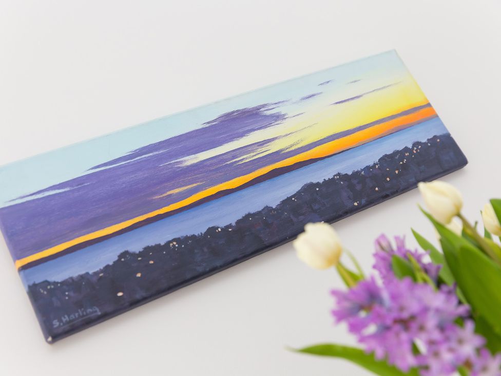 A painting of a sunset and a flower arrangement at 2 Remera St Ives