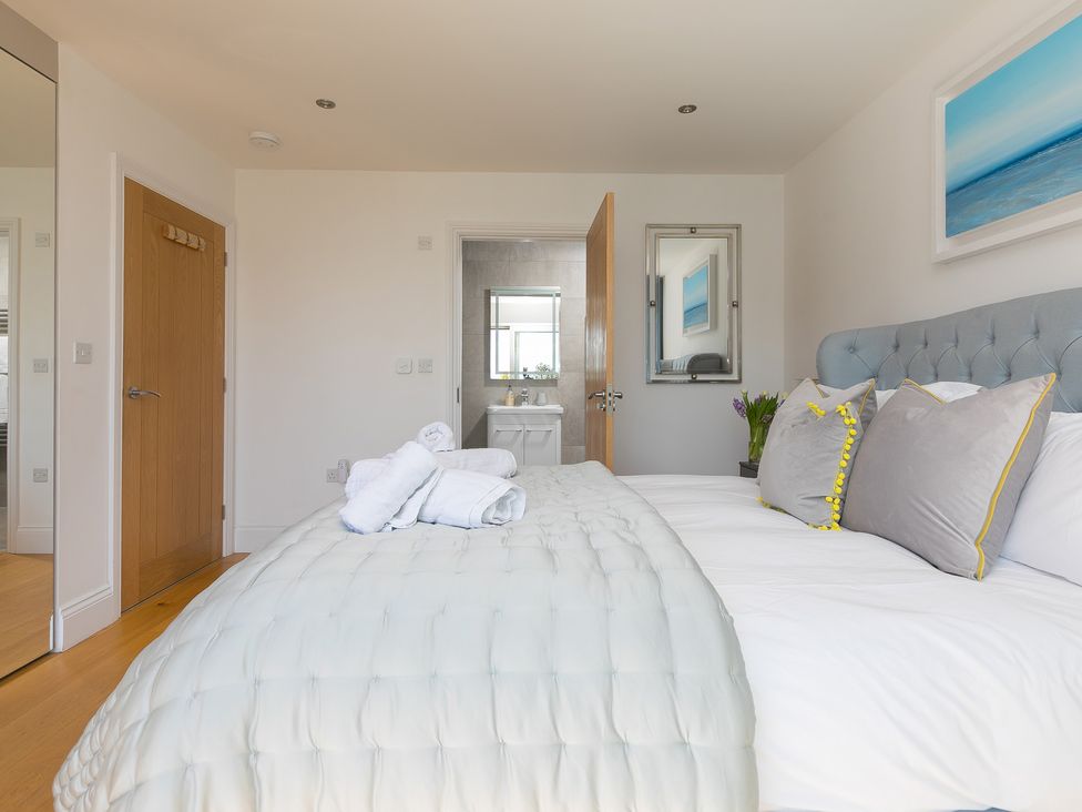 A bedroom with a bed and towels at 2 Remera in St Ives