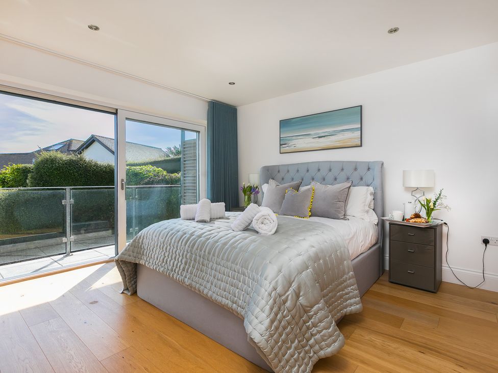A bedroom with a bed and sliding doors at 2 Remera in St Ives