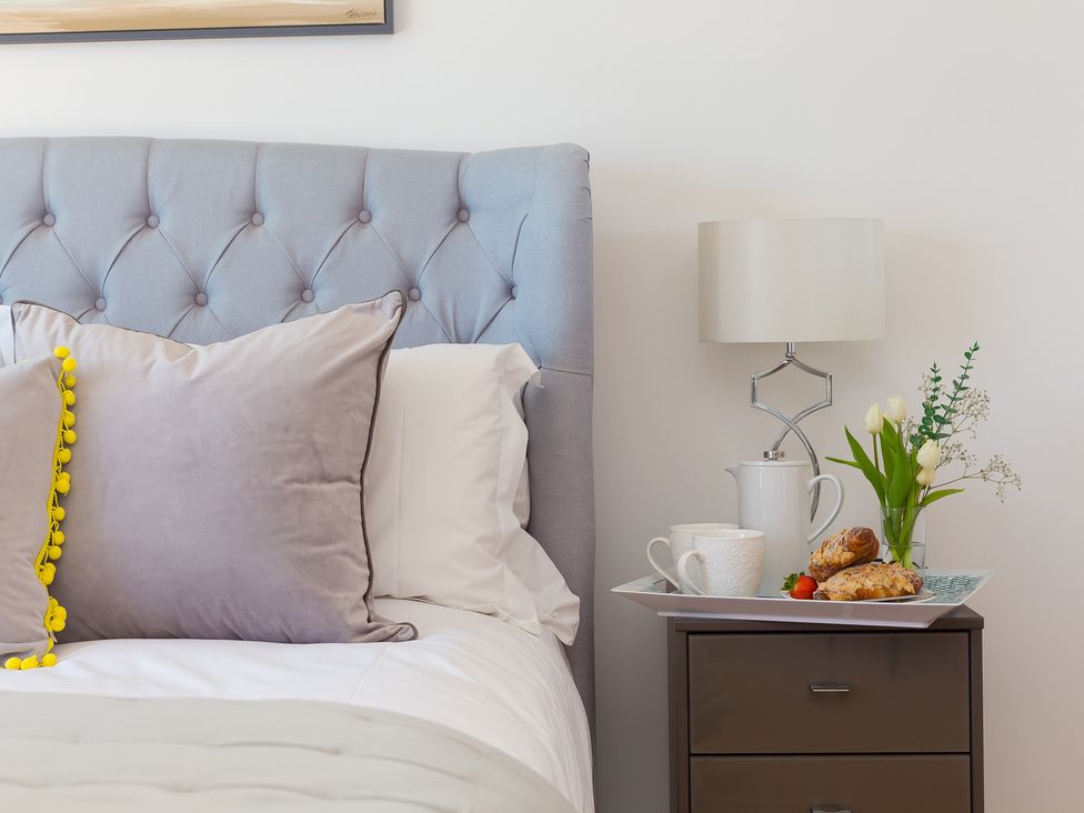 A bedroom with a bed, lamp, and breakfast tray at 2 Remera St Ives