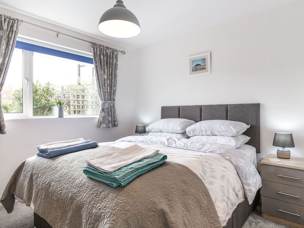 A bedroom with a bed and bedside tables at Orchard View in St. Austell