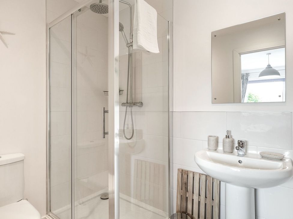 A bathroom with a shower, toilet, and sink at Orchard View in St. Austell