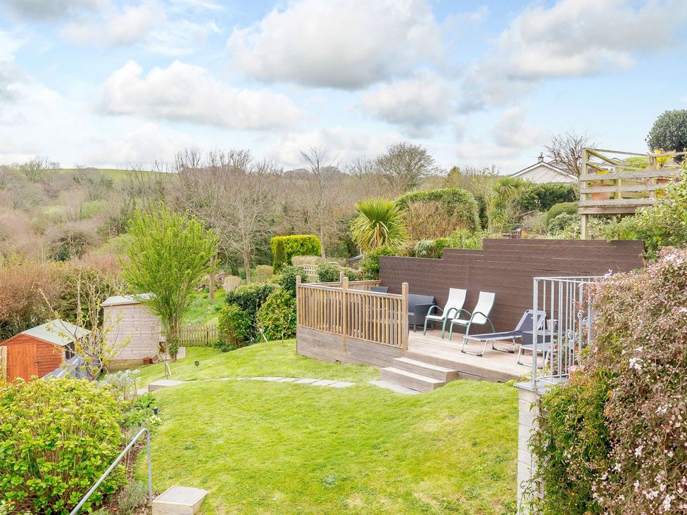 A garden with decking and lounge chairs at Orchard View in St. Austell