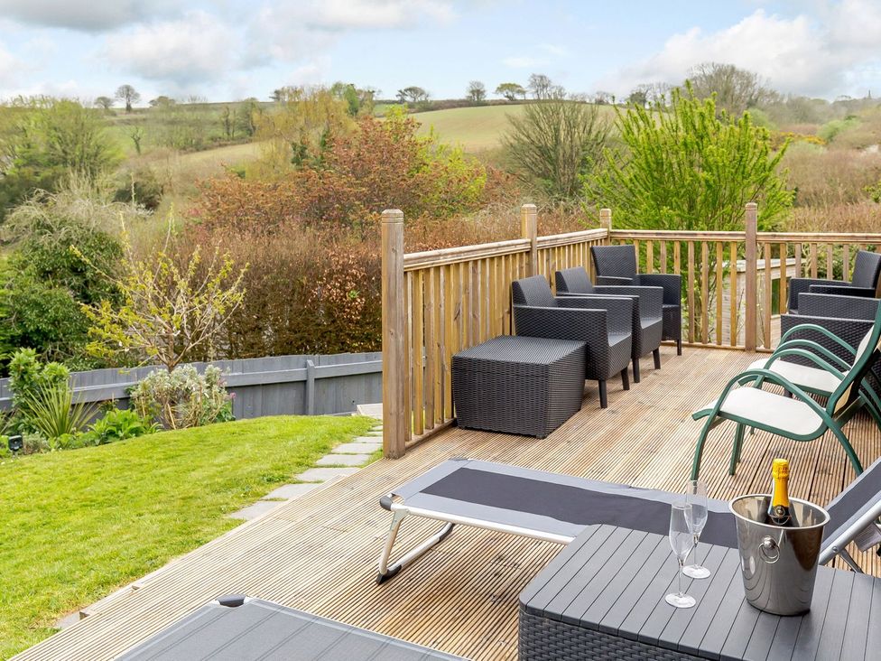 An outdoor seating area with chairs and table at Orchard View in St. Austell