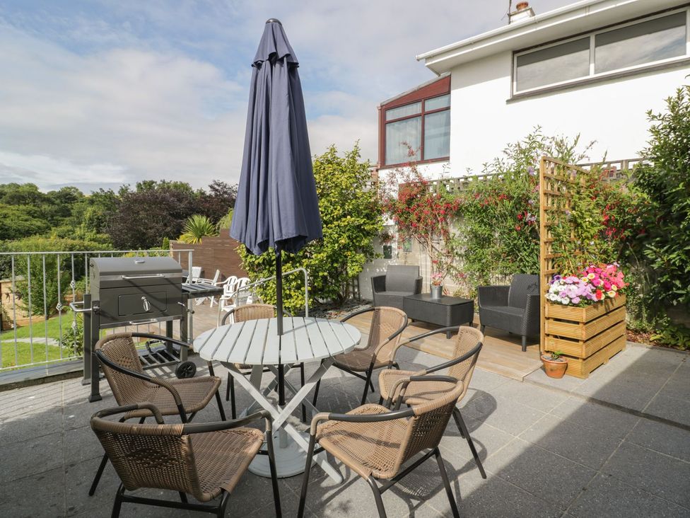 An outdoor seating area with a table and chairs at Orchard View in St. Austell