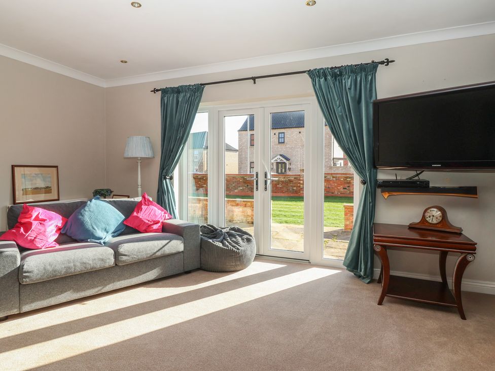 A living room with a sofa and television at The Redwoods