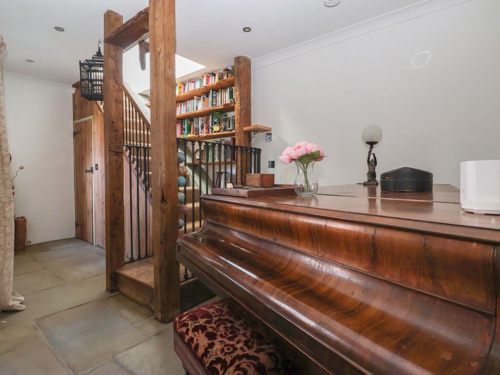A hallway with a piano and a staircase at The Redwoods 