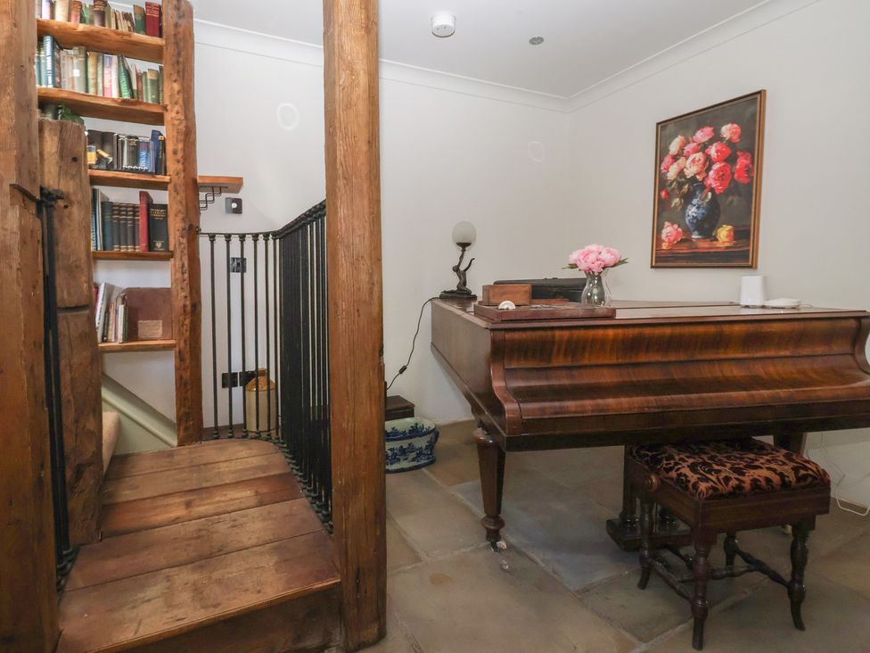 A music room with a piano and bookshelf at The Redwoods in 