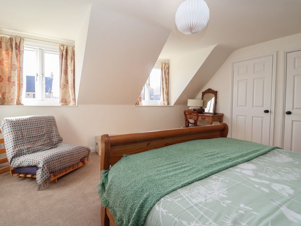 A bedroom with a bed, chair, desk and window at The Redwoods