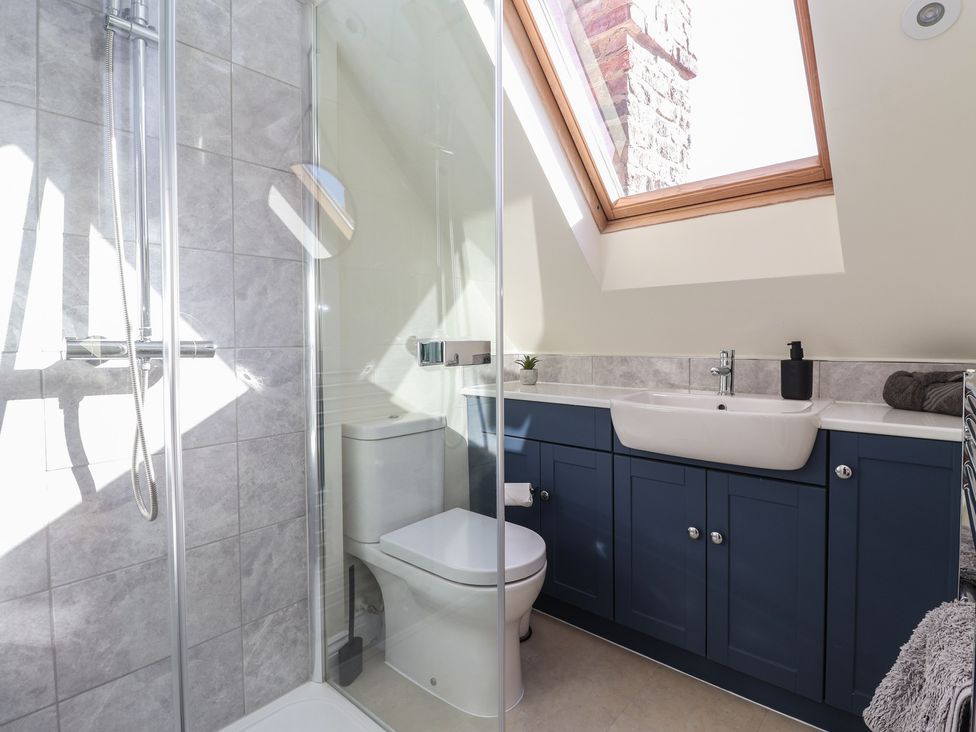 A bathroom with a shower, toilet, and sink at The Redwoods in 