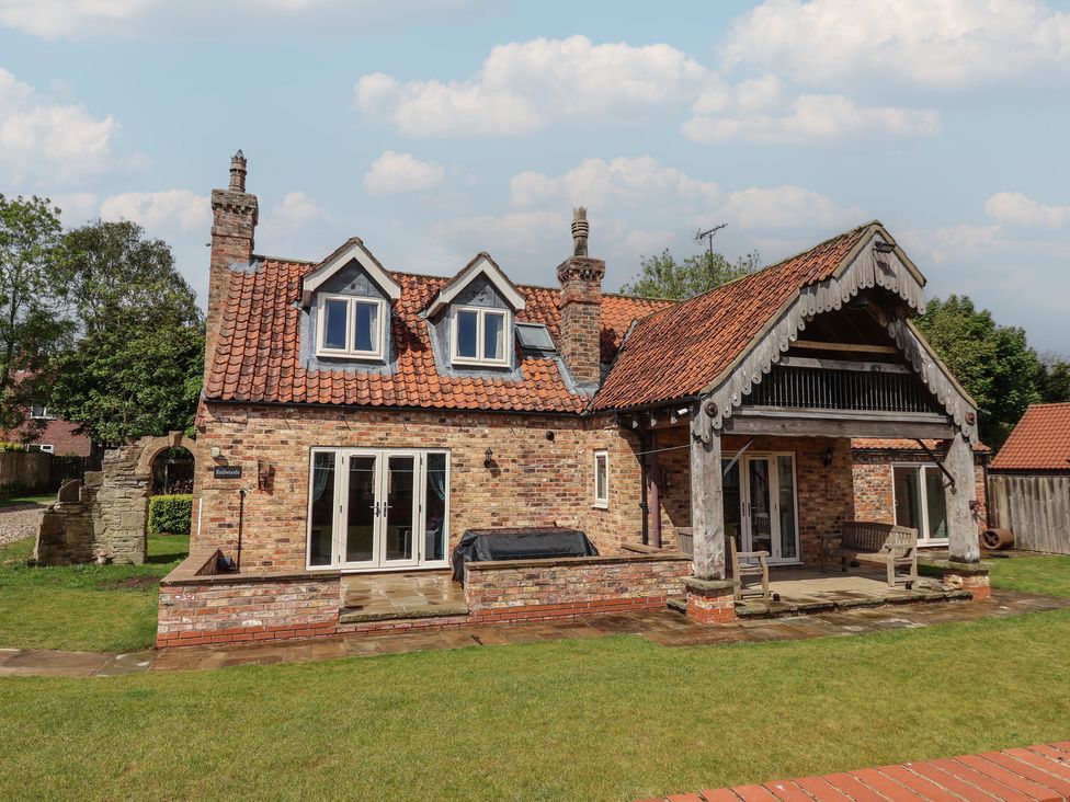 A house with a wooden deck and outdoor furniture at Redwoods Leven Near Beverley