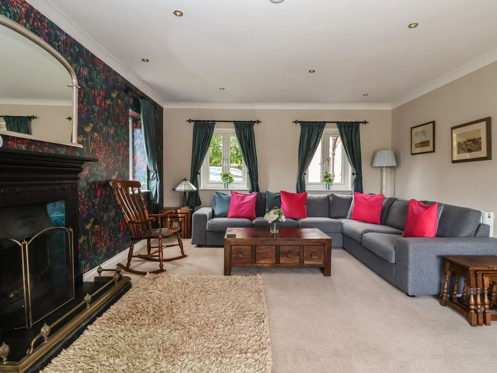 A living room with a sectional sofa and coffee table at Redwoods in Leven Near Beverley
