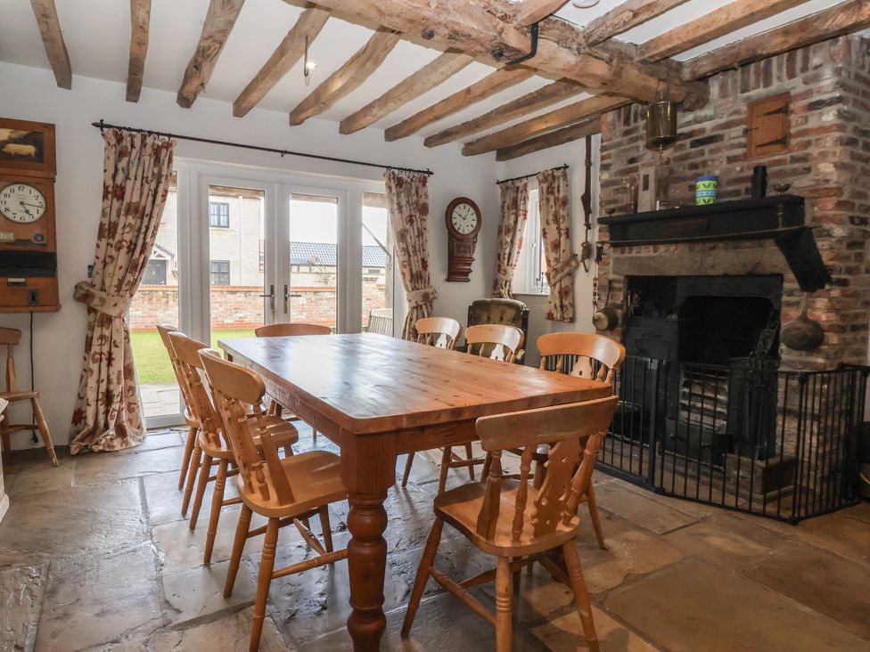 A dining room with a wooden table and chairs at Redwoods Leven Near Beverley