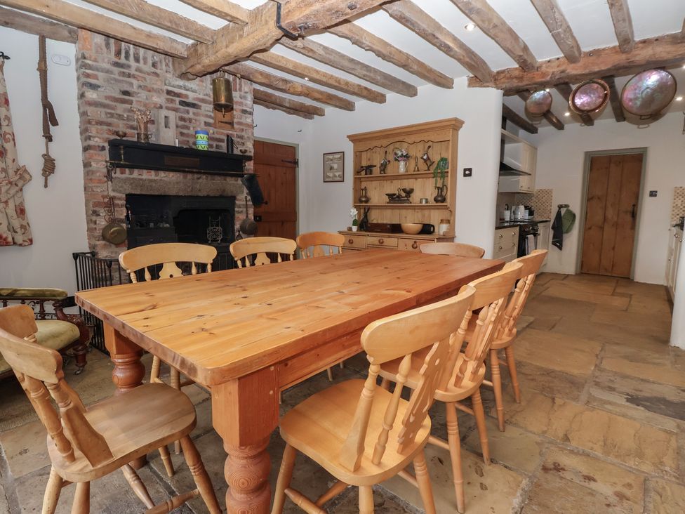 A dining room with a wooden table and chairs at Redwoods in Leven Near Beverley