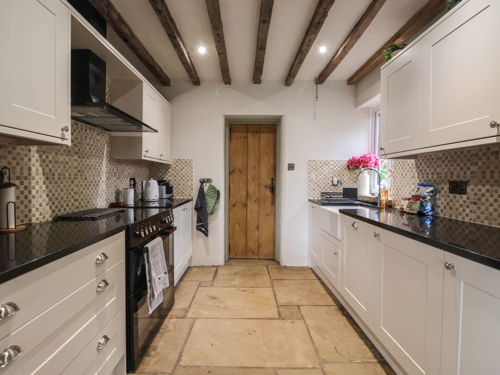 A kitchen with cabinets and a door at Redwoods Leven Near Beverley