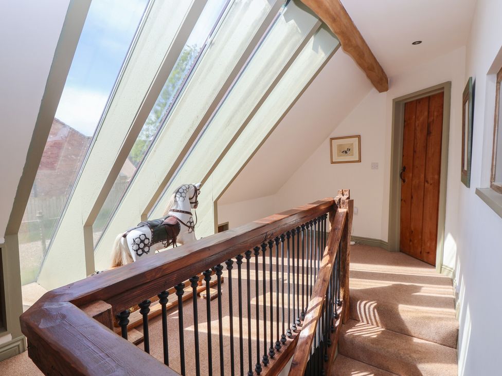 A hallway with a horse decoration and large windows at Redwoods Leven Near Beverley