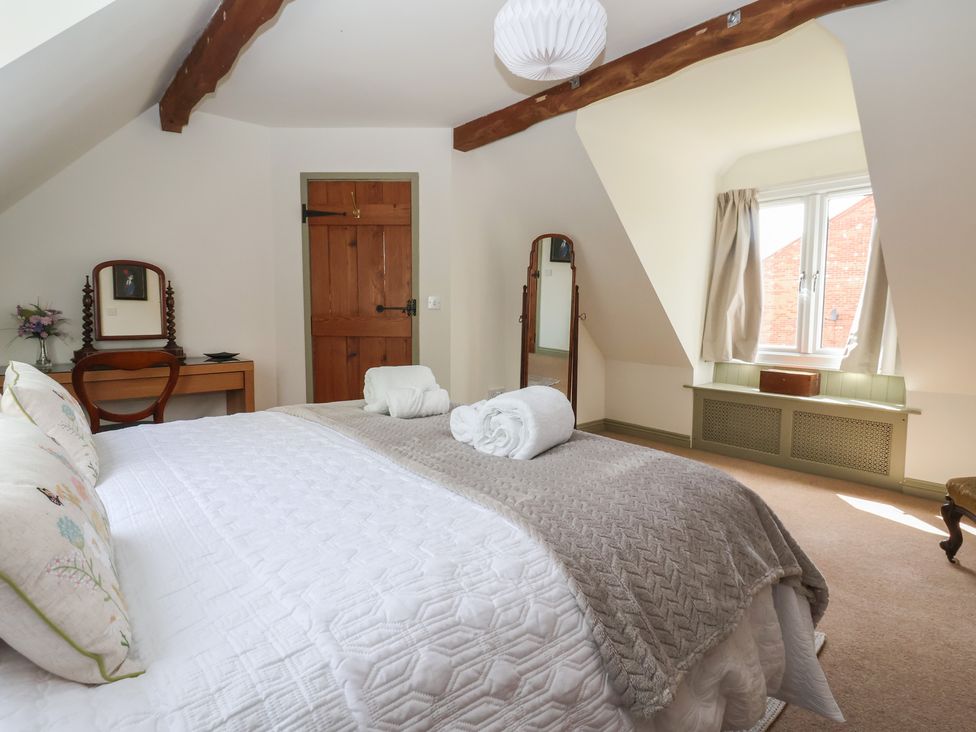 A bedroom with a bed and mirrors at Redwoods Leven Near Beverley