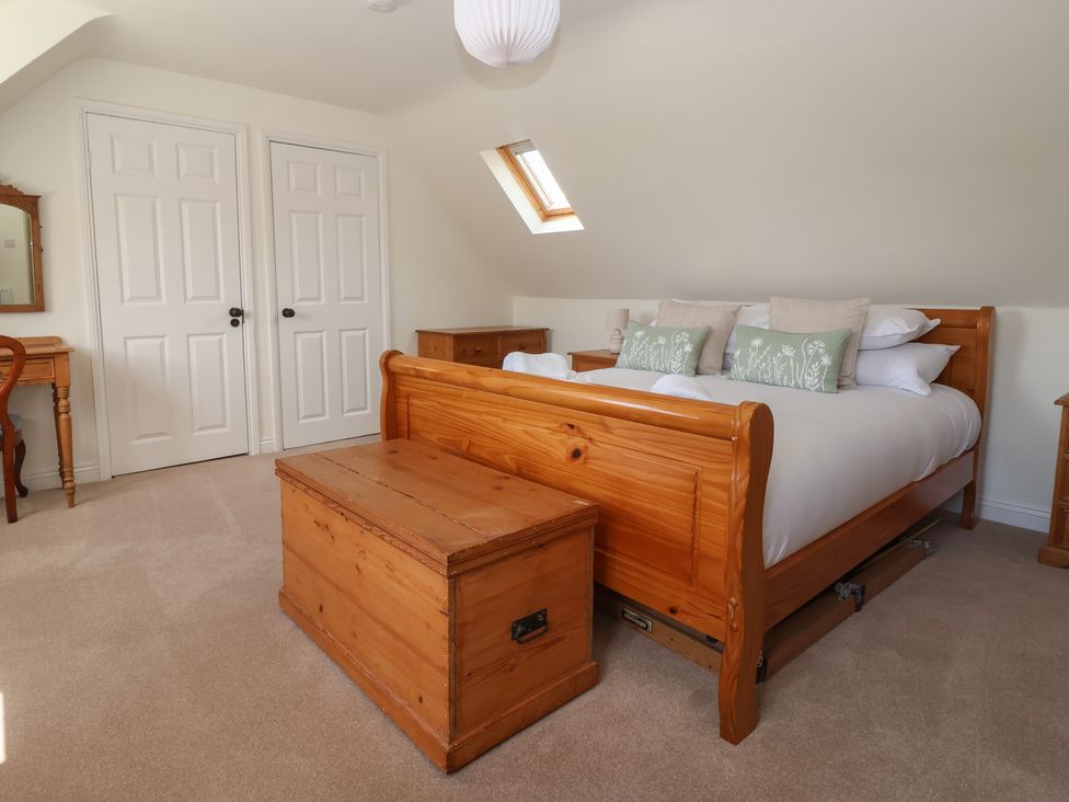 A bedroom with a bed and wooden furniture at Redwoods in Leven Near Beverley