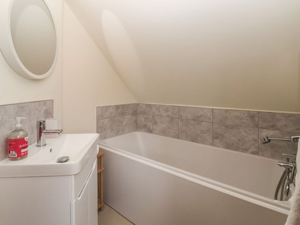 A bathroom with a sink and tub at Redwoods in Leven Near Beverley