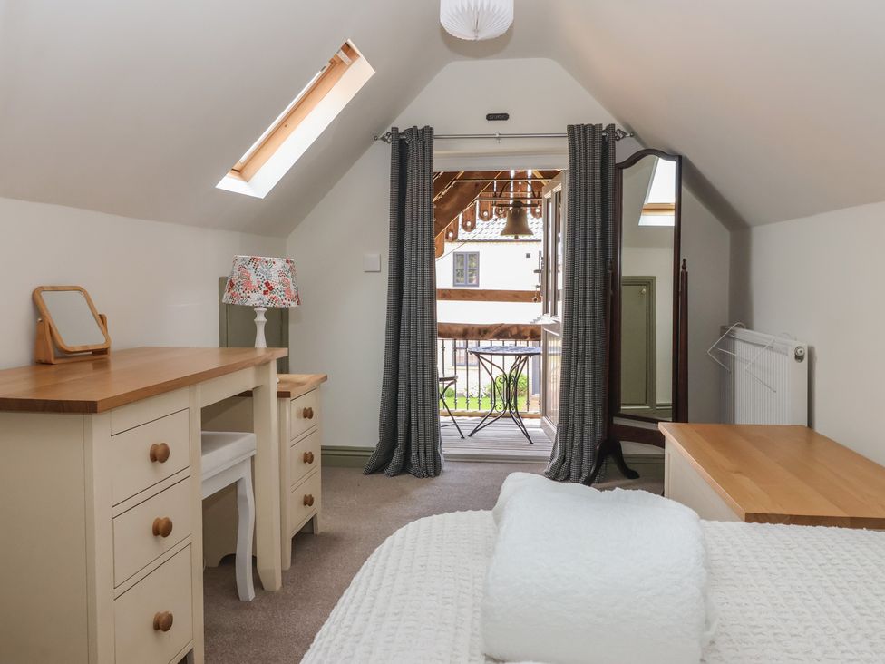 A bedroom with a desk and mirror at Redwoods Leven Near Beverley