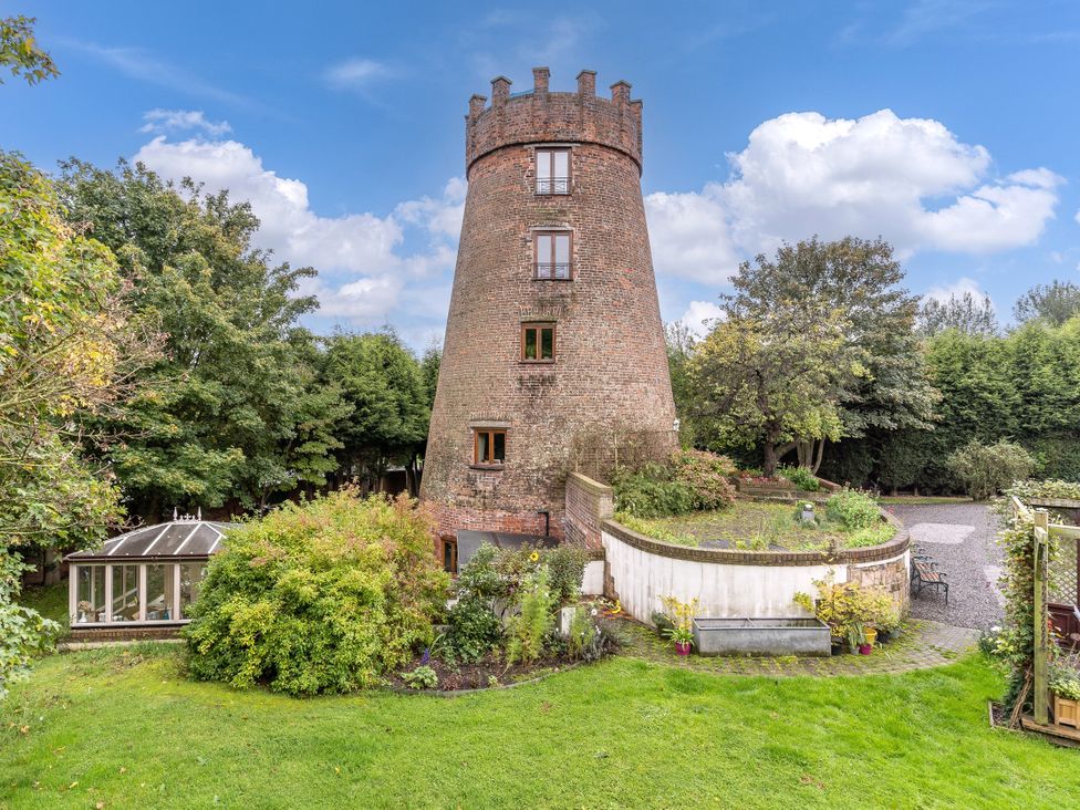 An outdoor view of a windmill surrounded by garden area at Hadley Park Windmill