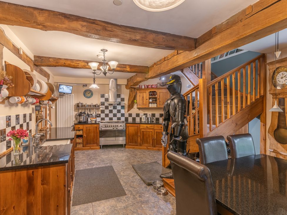 A kitchen with wooden cabinets and appliances at Hadley Park Windmill