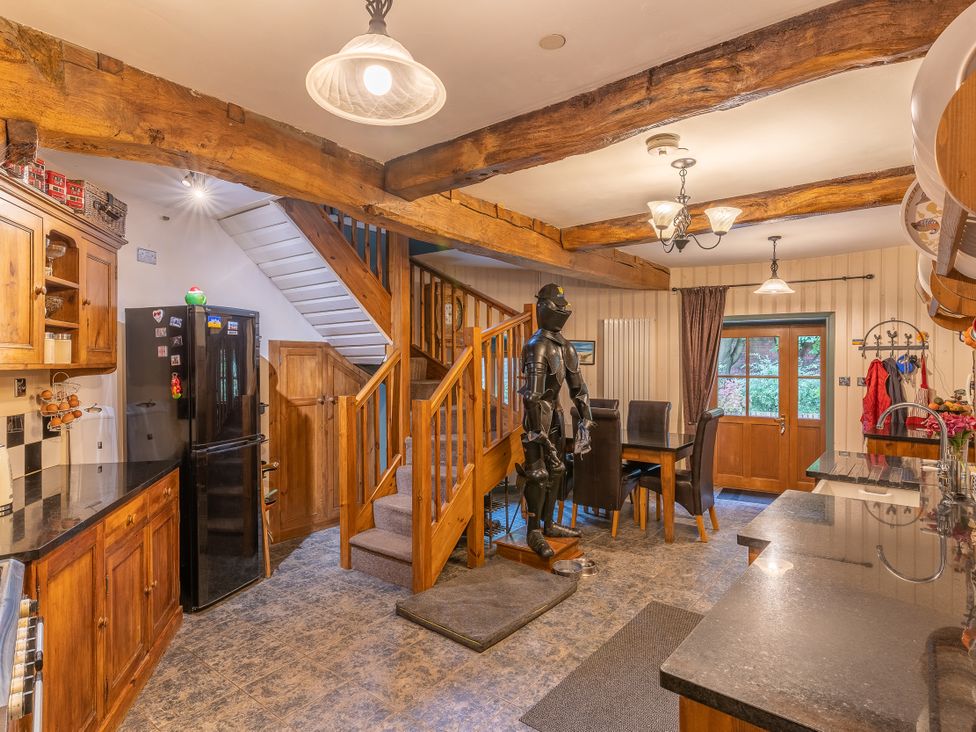 A kitchen with a staircase and a suit of armor at Hadley Park Windmill
