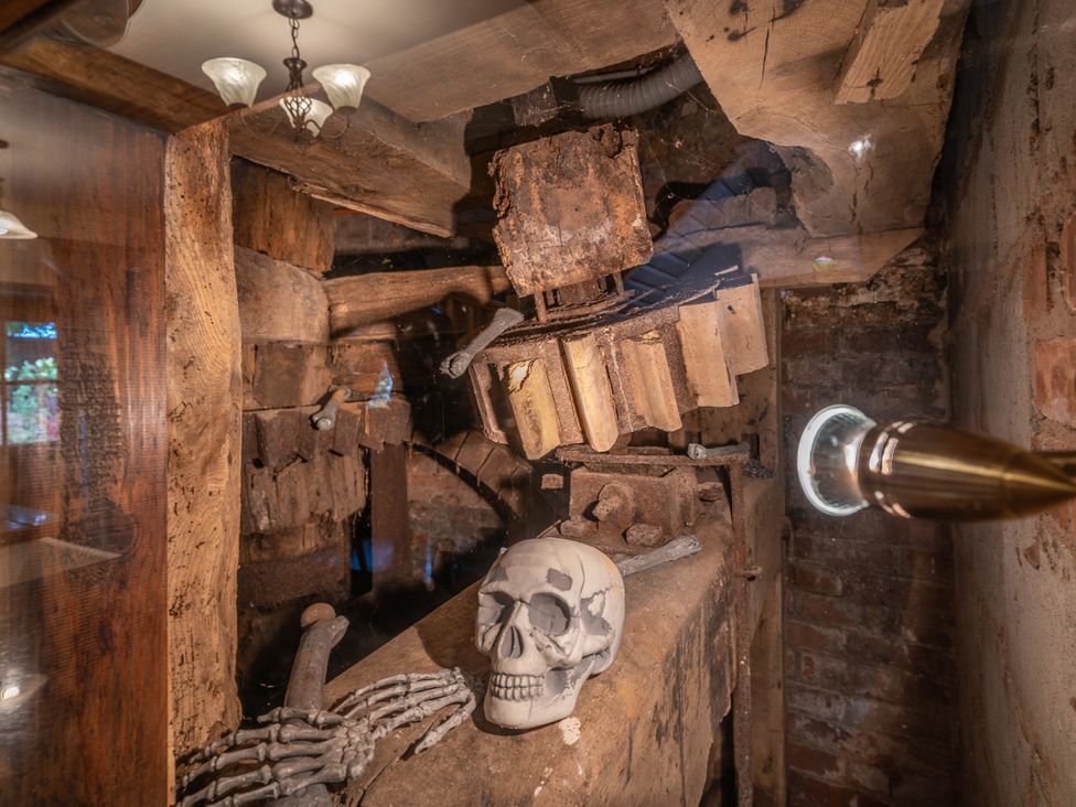A mill interior featuring machinery and a skeleton at Hadley Park Windmill 