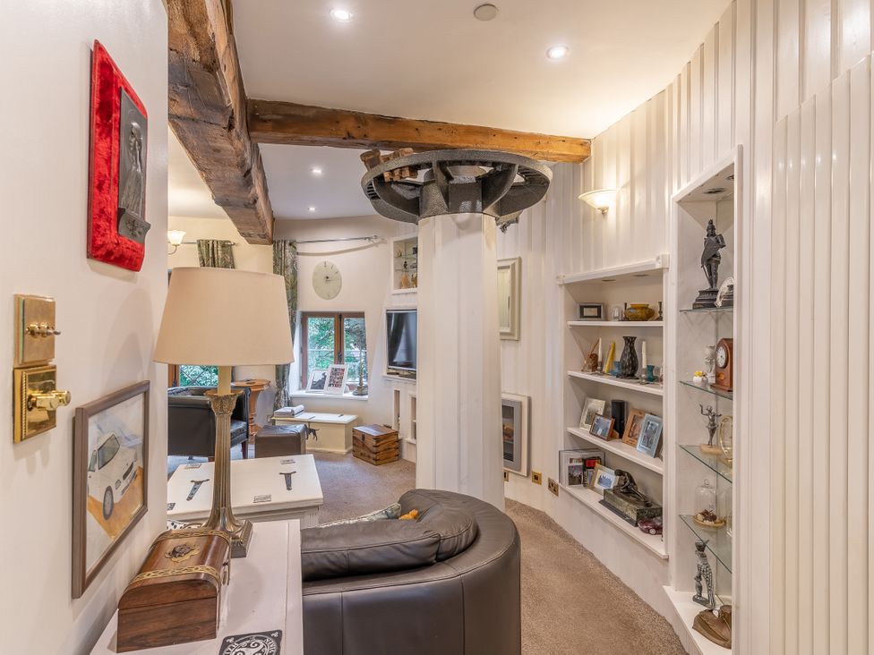 A living room with shelves and a lamp at Hadley Park Windmill