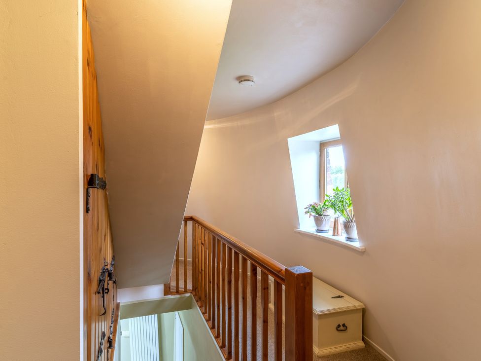A hallway with a staircase and window at Hadley Park Windmill