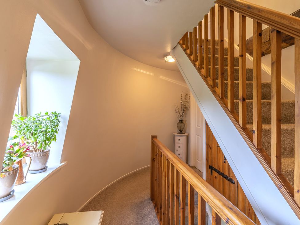 A hallway with a staircase and plants at Hadley Park Windmill 