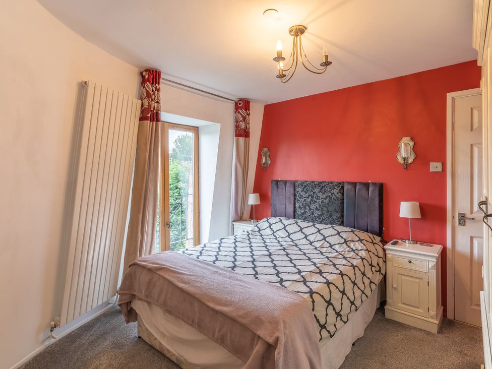 A bedroom with a bed and bedside tables at Hadley Park Windmill
