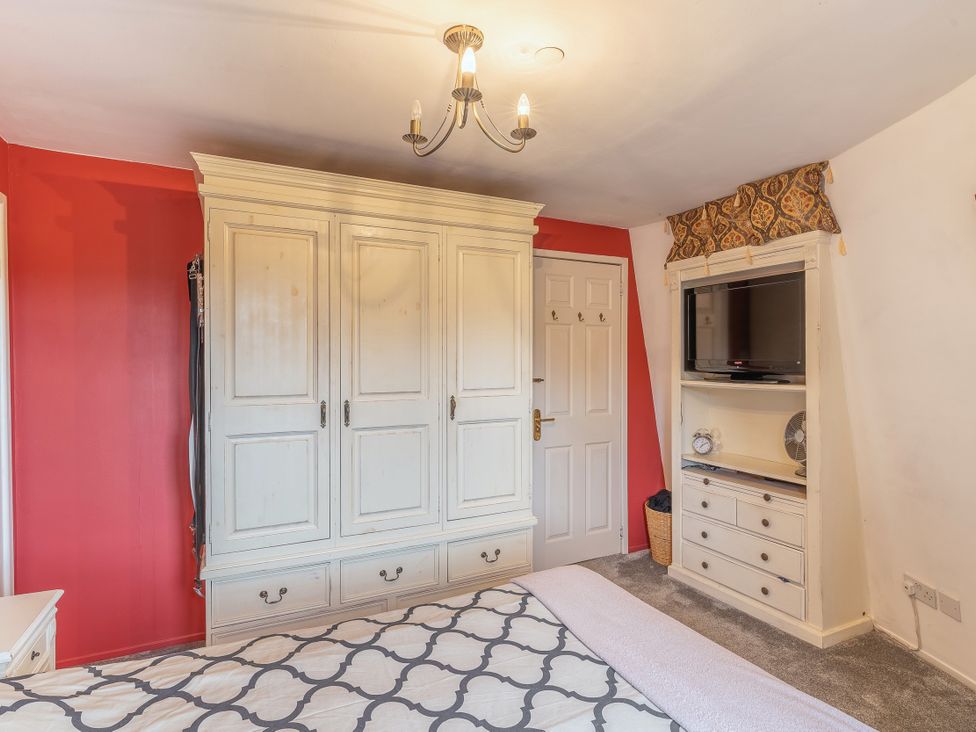 A bedroom with a wardrobe and television at Hadley Park Windmill