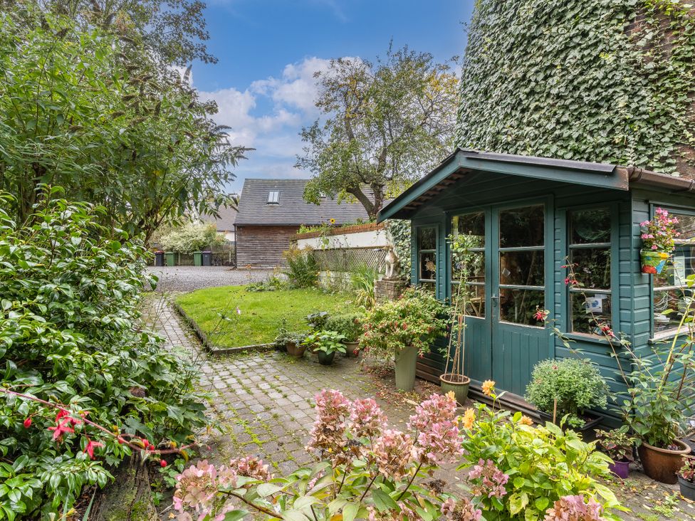 A garden with a shed and flower pots at Hadley Park Windmill