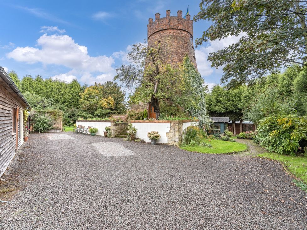 An outdoor area with a tower and garden features at Hadley Park Windmill
